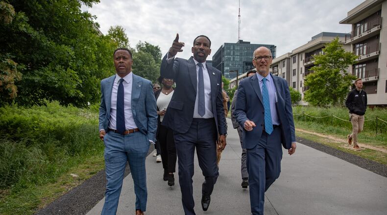 Beltline Inc. CEO and President Clyde Higgs (from left), Atlanta Mayor Andre Dickens and White House senior adviser Tom Perez stroll down the eastside trail of the Beltline on April 24, 2024, ahead of an announcement that a majority of the trail loop will be completed ahead of the 2026 FIFA World Cup. (Riley Bunch/AJC 2024)