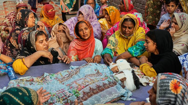 EDS NOTE: GRAPHIC CONTENT - Women mourn around the bodies of their children, who were killed in the roof collapse at a tutoring center that was under construction on the outskirts of Lahore, Pakistan, Wednesday, July 1, 2026. (AP Photo/K.M. Chaudary)