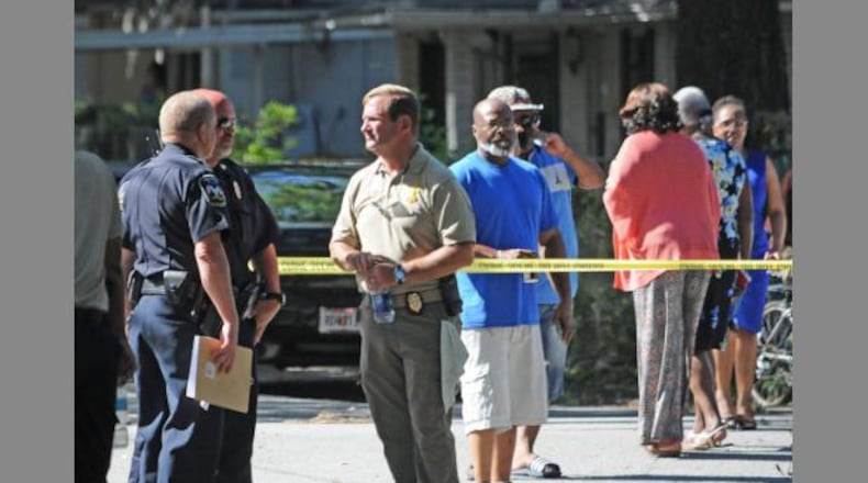 Brunswick police Chief Terry Jones (center) talks with officers at the scene of a triple slaying. (Credit: Florida Times-Union)