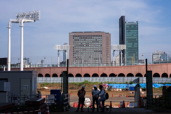 Workers at a construction site near the Jingu stadium in Tokyo, Wednesday, July 3, 2025. (AP Photo/Louise Delmotte)
