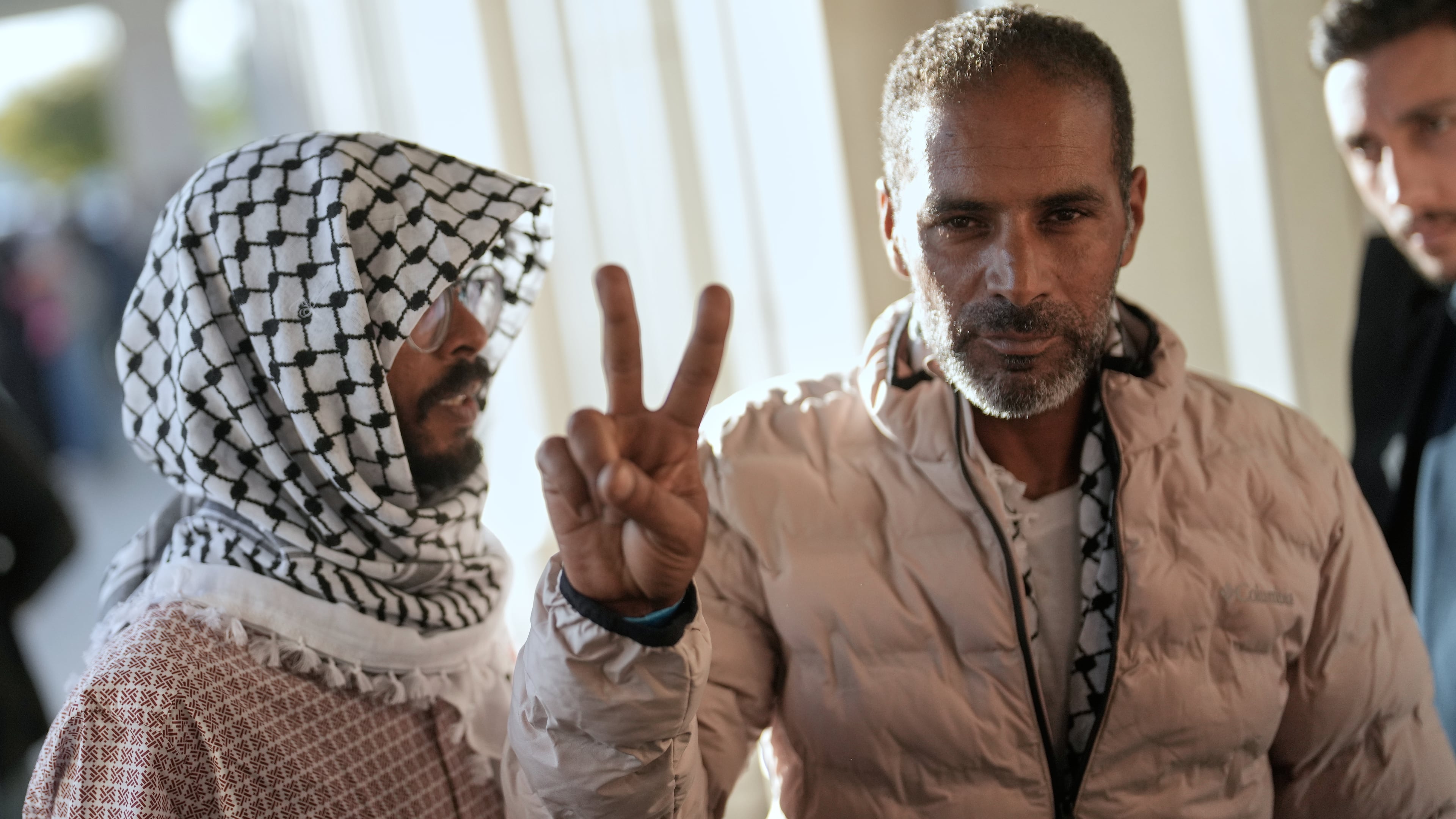 Activists from the Global Sumud Flotilla give the peace sign after arriving at Istanbul Airport in Istanbul, Turkey, Saturday, Oct. 4, 2025. (AP Photo/Khalil Hamra)