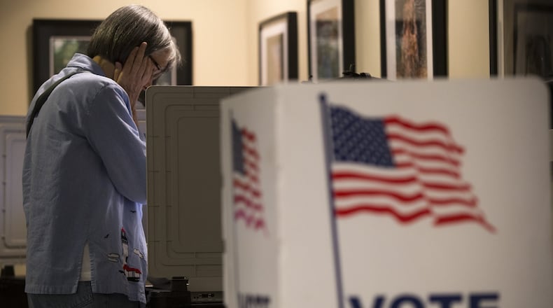 A woman votes at the Buckhead Library in Atlanta, Georgia, on Monday, Oct. 26, 2017. Monday was the first day of early voting in Atlanta, where citizens cast their ballots for the upcoming mayoral election as well as other local elections. On the first day, turnout was sparse at several locations. (CASEY SYKES / CASEY.SYKES@AJC.COM)