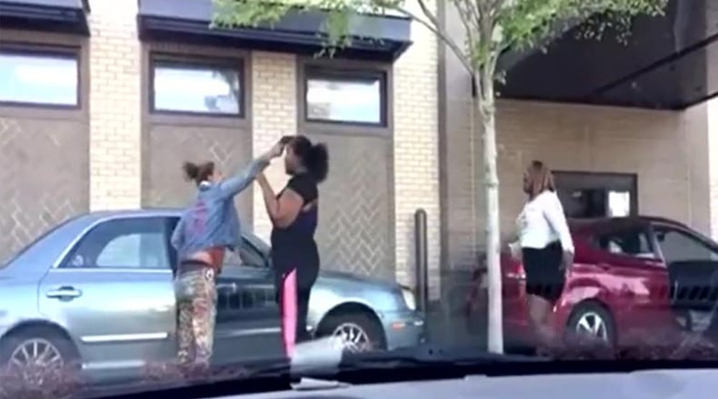Video of a fight outside an Atlanta Chick-fil-A showed a woman pull a gun on another and hold it against her forehead.
