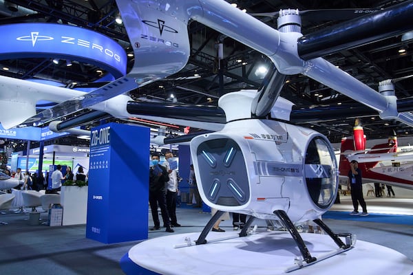 Visitors tour the ZEROG booth showcasing it ZG-ONE, a two-seated eVTOL multicopter aircraft with its autonomous piloting at the 3rd Exhibition of Technology and Education in Civil Aviation as China promoting the low-altitude economy, in Beijing, Tuesday, May 27, 2025. (AP Photo/Andy Wong)