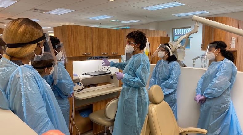 Atlanta Technical College instructor Krishana Cureton (center) talks to students about procedures to prepare patients for treatment in her dental hygiene class. ERIC STIRGUS / ERIC.STIRGUS@AJC.COM