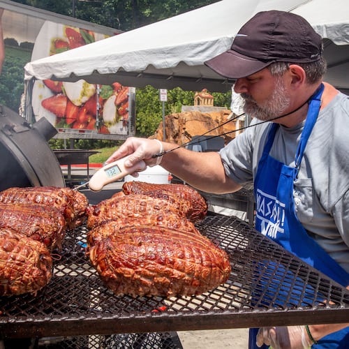 Peter Tiller checks on his smoked lamb during the 29th annual Marietta Greek Festival in Marietta on Saturday, May 18, 2019. (Steve Schaefer for the AJC)