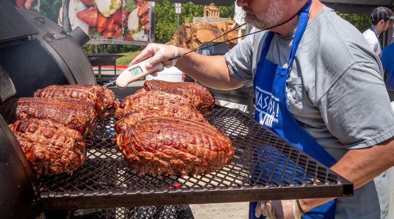 Peter Tiller checks on his smoked lamb during the 29th annual Marietta Greek Festival in Marietta on Saturday, May 18, 2019. (Steve Schaefer for the AJC)