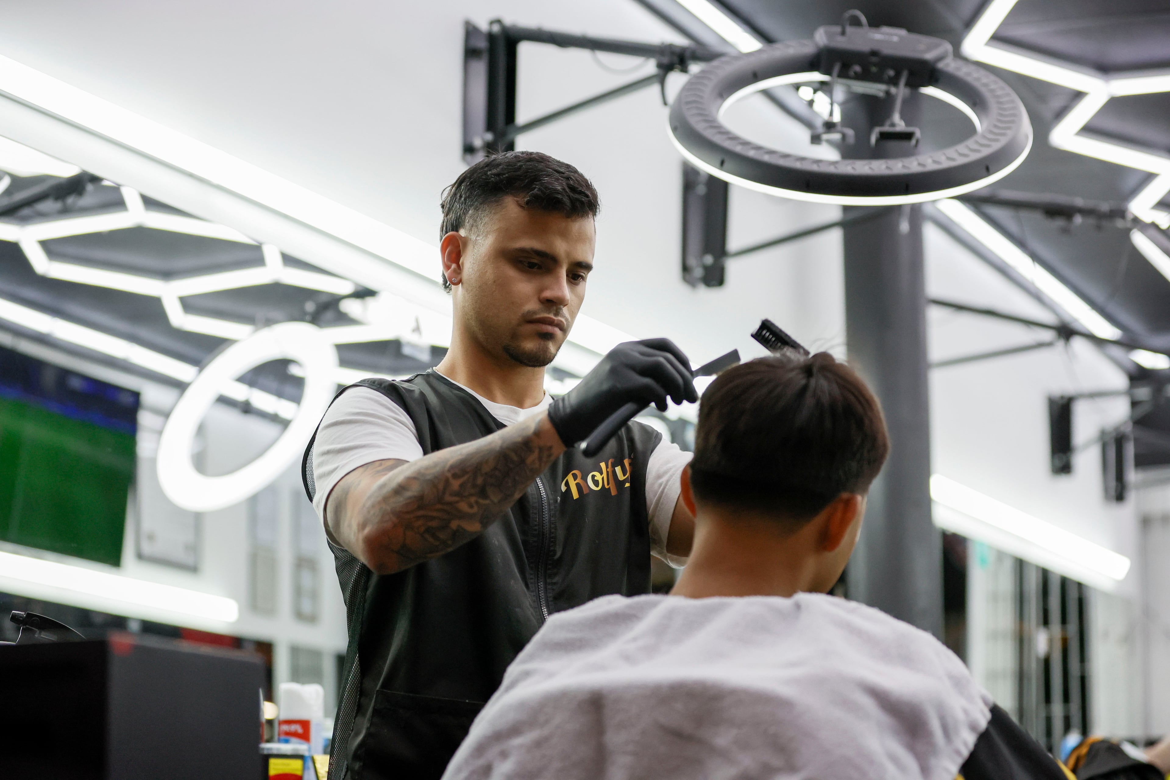 Barber Julio Gutierrez works with a customer in Plaza Fiesta, May 7, 2025. He has seen his revenue drop 40% since the beginning of President Donald Trump's second term.
(Miguel Martinez/AJC)