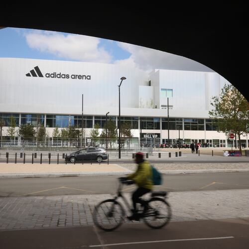 FILE - A cyclist rides past the Adidas Arena, April 18, 2024, in Paris, France. (AP Photo/Thomas Padilla, File)