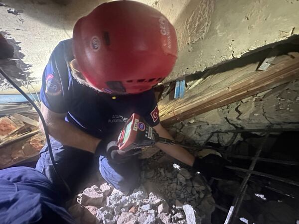 Rescuers pulling two men alive from the ruins of a hotel in Myanmar's capital, Wednesday, April 2, 2025. (GEA Search and Rescue via AP)