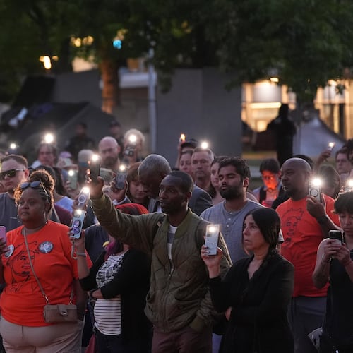 People hold smartphone with flash light during the vigil for victims the day after a shooting at Seattle Center during the Bite of Seattle food festival, Monday, July 27, 2026, in Seattle. (AP Photo/Lindsey Wasson)