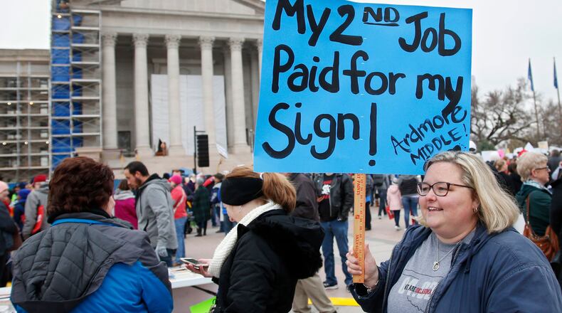An Oklahoma teacher holds a sign as teachers rally against low school funding at the state Capitol in Oklahoma City in April. Teacher pay and school funding have become flashpoints in many states.