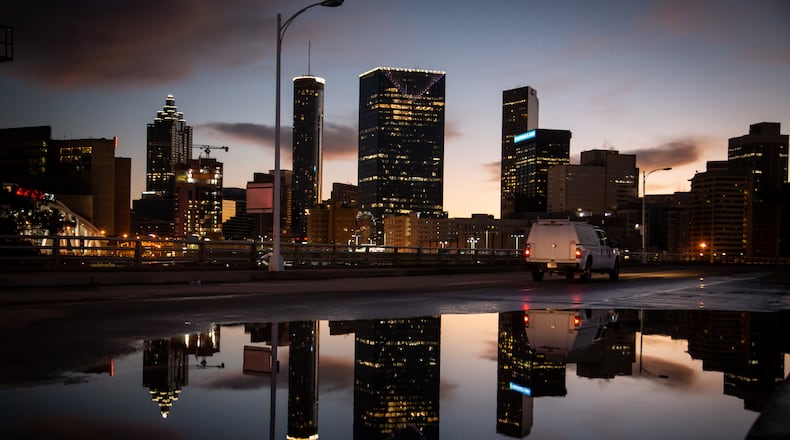 The Atlanta skyline is reflected in a large puddle near the Mercedes-Benz Stadium Monday morning, February 8, 2021 STEVE SCHAEFER FOR THE ATLANTA JOURNAL-CONSTITUTION