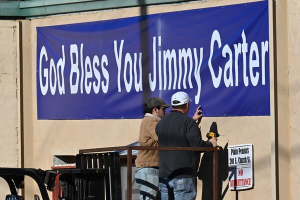 A banner reading “God Bless You Jimmy Carter” is being installed in Plains on Wednesday. Hyosub Shin/AJC