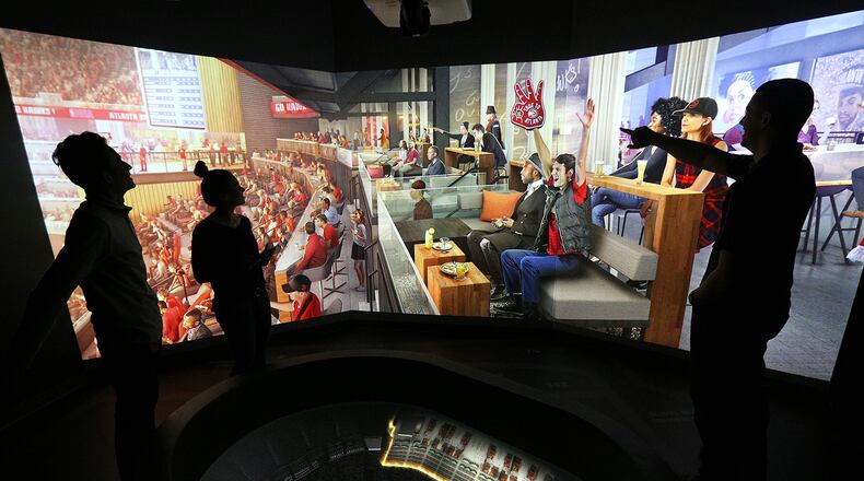 Arpan Patel (from left), Addison Nunes and Aaron Coffey, working “The Pit” feature in the Philips Arena preview center, run a projection of the Atlanta Social area, one of the changes coming to the arena in the fall.