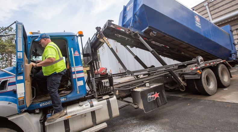 Greg Dowis transports full commercial garbage bins to the landfill, shovels trash, does paperwork and replaces empty containers in Johns Creek on Thursday, April 9, 2020. Dowis, who has been in waste management for more than 22 years, is worried that his employer isn’t providing masks, gloves or other protective gear. (Jenni Girtman for Atlanta Journal-Constitution)
