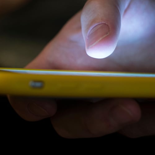FILE - A man uses a cell phone in New Orleans on Aug. 11, 2019. (AP Photo/Jenny Kane, File)