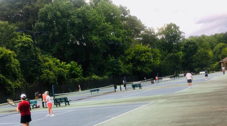 The five tennis courts at Decatur’s Glenlake Park were mostly full Tuesday night, one day after the reopening of all nine city-owned parks. Bill Banks for the AJC