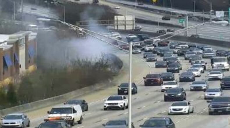 A fire outside a Roswell Road Goodwill store sends smoke across I-85.