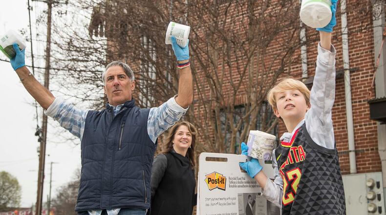 Trevelino/Keller marketing firm co-founders Dean Trevelino, left, and Genna Keller and Marshall Hood gave away toilet paper Monday evening. ALYSSA POINTER/ALYSSA.POINTER@AJC.COM
