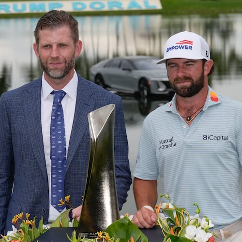 Cameron Young, right, stands with Eric Trump as he poses with the trophy after winning the Cadillac Championship PGA golf tournament Sunday, May 3, 2026, in Doral, Fla. (AP Photo/David J. Phillip)