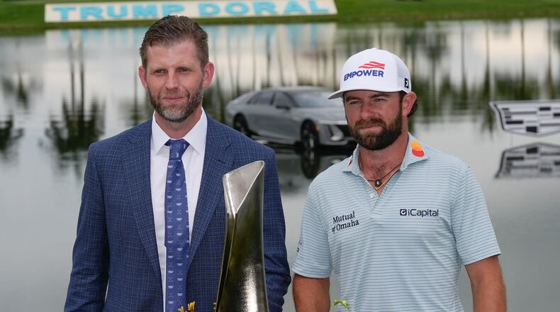 Cameron Young, right, stands with Eric Trump as he poses with the trophy after winning the Cadillac Championship PGA golf tournament Sunday, May 3, 2026, in Doral, Fla. (AP Photo/David J. Phillip)