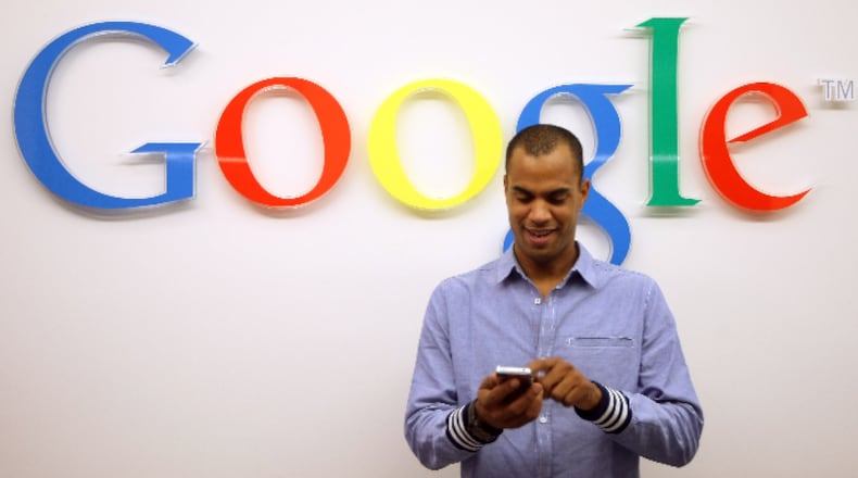 A visitor uses a cell phone in front of the Google logo on September 26, 2012 at the official opening party of the Google offices in Berlin, Germany.