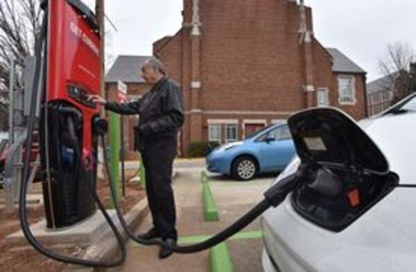 A resident charges an electric vehicle at a station in Decatur.