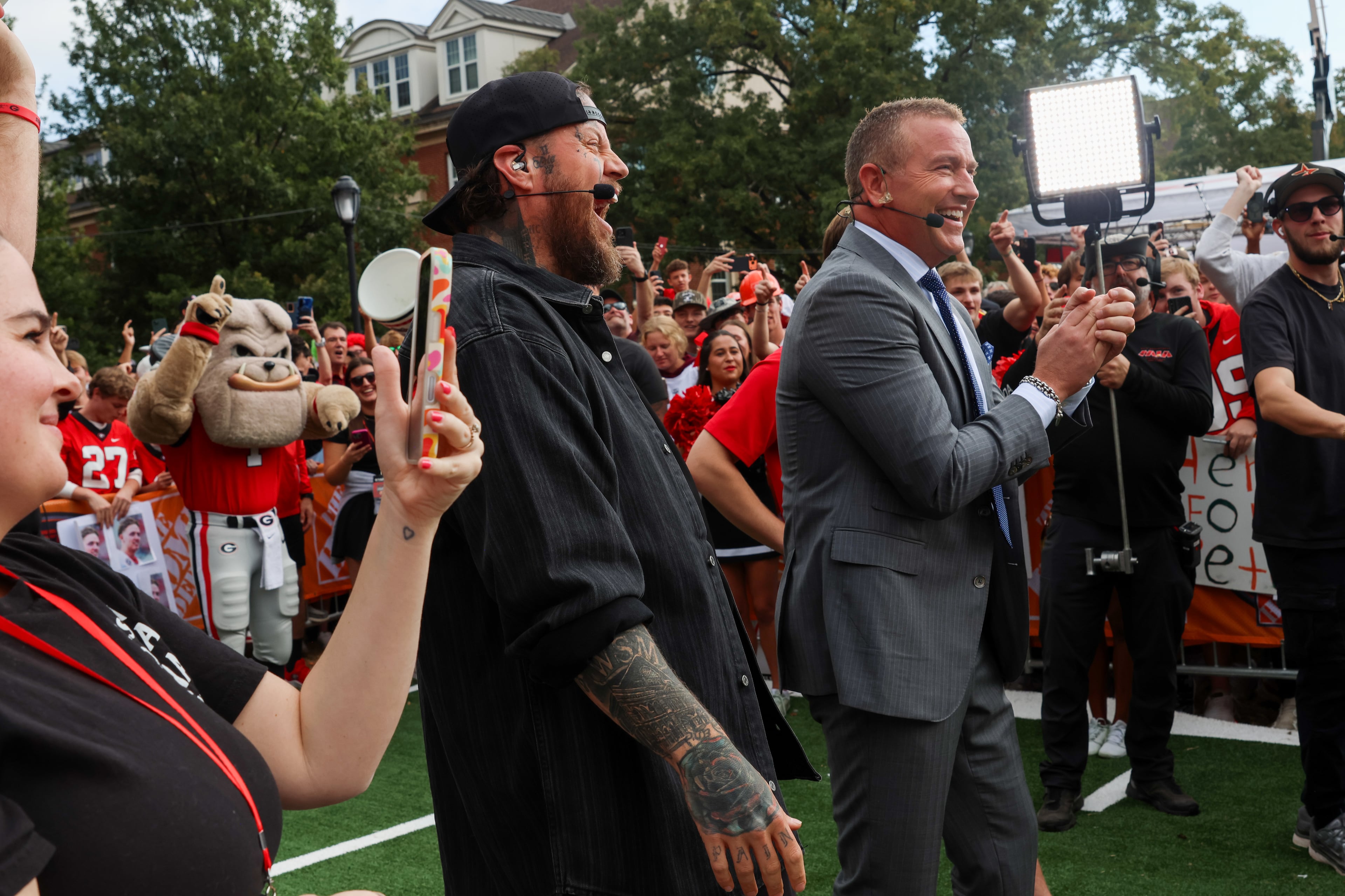 Singer-songwriter Jelly Roll (left) and analyst Kirk Herbstreit celebrate during the Pat McAfee kicking contest on the ESPN College GameDay broadcast from Myers Quad at UGA on Saturday, Oct. 18, 2025. Jelly Roll is the week’s celebrity guest picker. (C.J. Bartunek for the AJC)