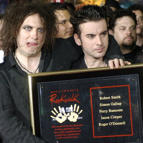 FILE - Robert Smith, left, Simon Gallup, center, and Perry Bamonte of British rock group The Cure hold a plaque after being inducted into Hollywood's Rockwalk in Los Angeles, Friday, April 30, 2004. (AP Photo/Chris Pizzello, File)