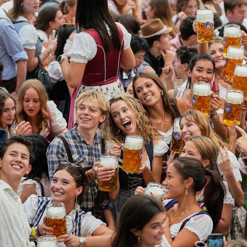 Young people cheer after the opening of the 191st Oktoberfest beer festival in Munich, Germany, Saturday, Sept.19, 2026. (AP Photo/Matthias Schrader)