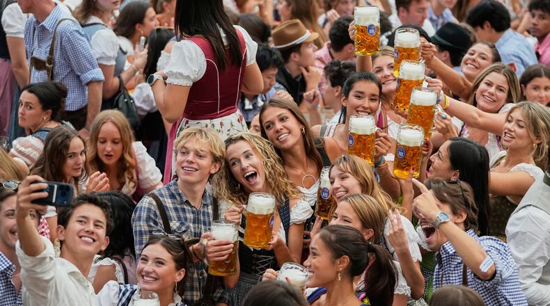 Young people cheer after the opening of the 191st Oktoberfest beer festival in Munich, Germany, Saturday, Sept.19, 2026. (AP Photo/Matthias Schrader)