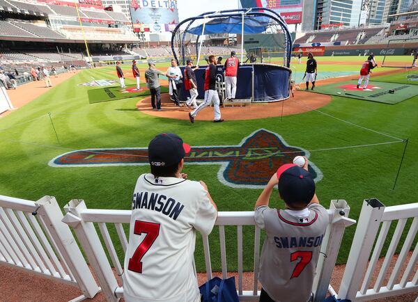 Matthew Walker (left), 13, and his brother Andrew, from Charlotte, watch batting practice during the Braves home opener in their new stadium at SunTrust Park on Friday.