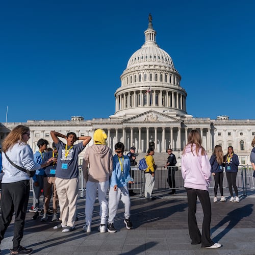 Students from Columbus, Ohio, wait outside a barrier as U.S. Capitol Police watch over the East Plaza where congressional leaders will have a news conferences on the government shutdown at the Capitol in Washington, Wednesday, Oct. 15, 2025. (AP Photo/J. Scott Applewhite)