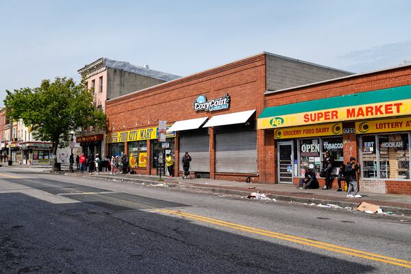 Litter lines the street as people walk and congregate on Pennsylvania Avenue near the Sandtown-Winchester neighborhood in Baltimore, Monday, April 14, 2025. (AP Photo/Stephanie Scarbrough)