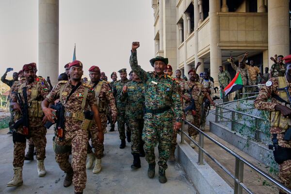 Sudan's military chief Gen. Abdel-Fattah Burhan center, is greeted by troops as he arrives at the Republican Palace, recently recaptured from the Rapid Support Forces paramilitary group, in Khartoum, Sudan, Wednesday, March 26, 2025. (AP Photo)