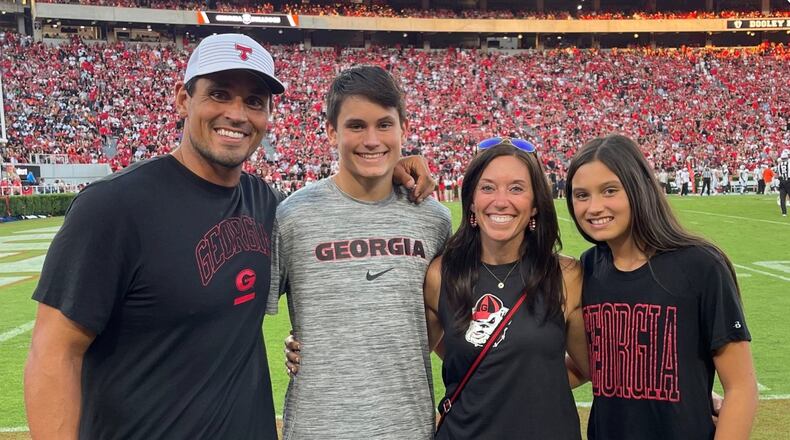 Bulldogs great and College Football Hall of Famer David Pollack (left), shown here with his family along the sidelines of Sanford Stadium during a UGA home game, was a standout defensive player for Georgia from 2001 through 2004. (Courtesy of the Pollack family from UGA Athletics)