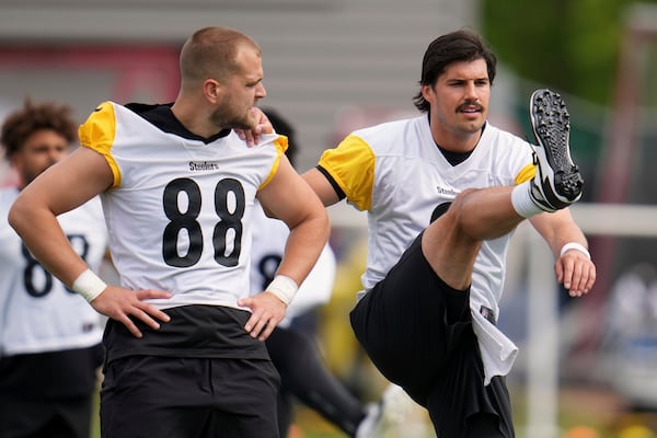Pittsburgh Steelers quarterback Mason Rudolph, right, gets a hand from tight end Pat Freiermuth (88) during the NFL football team's OTA's in Pittsburgh Tuesday, May 27, 2025. (AP Photo/Gene J. Puskar)