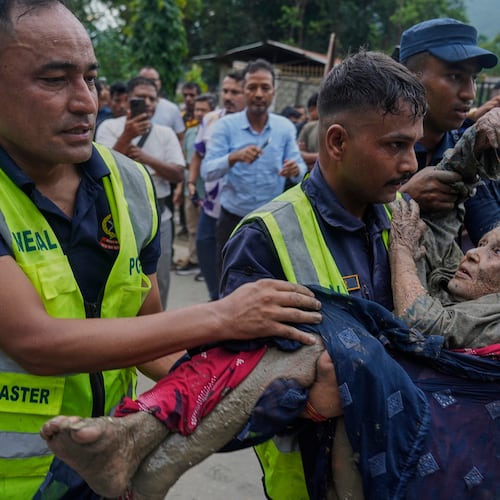 Rescuers carry a victim of flash flooding to safety along the Trishuli River in Nepal's Nuwakot district, Wednesday, Aug. 26, 2026. (AP Photo/Niranjan Shrestha)