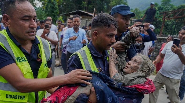 Rescuers carry a victim of flash flooding to safety along the Trishuli River in Nepal's Nuwakot district, Wednesday, Aug. 26, 2026. (AP Photo/Niranjan Shrestha)