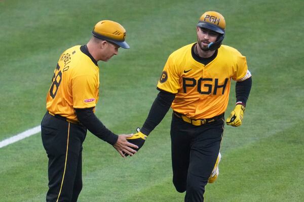 Pittsburgh Pirates' Jared Triolo, right, is greeted by third base coach Mike Rabelo, left, as he rounds third after hitting a solo home run off Atlanta Braves pitcher Bryce Elder during the sixth inning of a baseball game in Pittsburgh, Friday, May 9, 2025. (AP Photo/Gene J. Puskar)