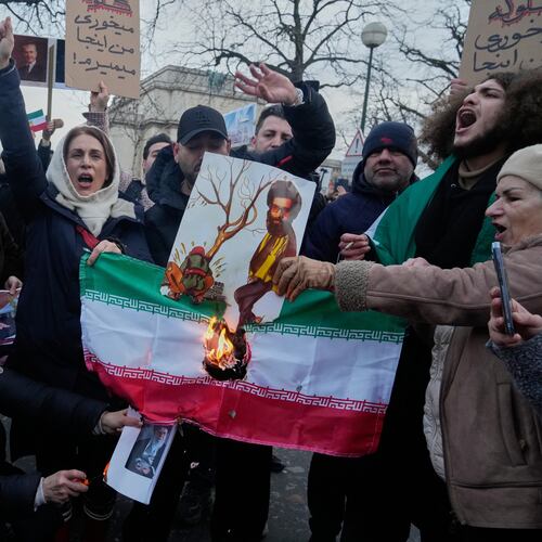 Protesters burn the Iranian national flag during a rally in support of the nationwide mass demonstrations in Iran against the government in Paris, Sunday, Jan. 11, 2026. (AP Photo/Michel Euler)