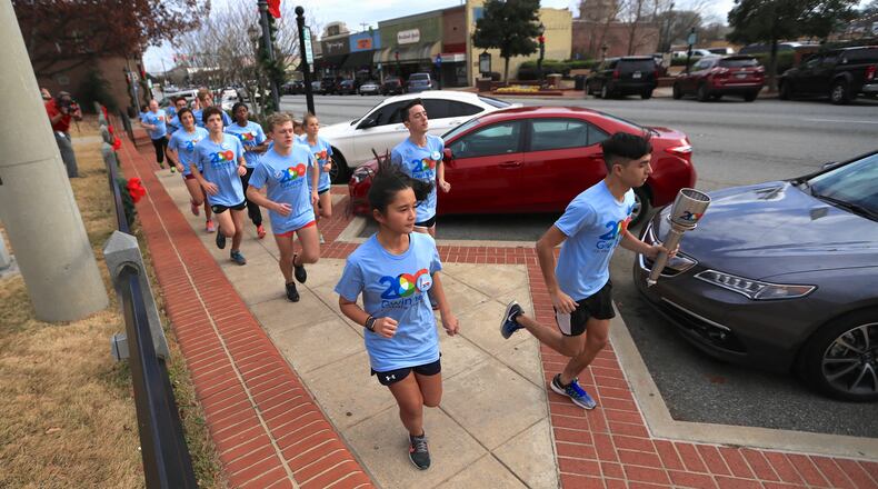 Students representing Gwinnett high schools carries the county’s bicentennial torch to help kick off a year of celebration. Courtesy Gwinnett County