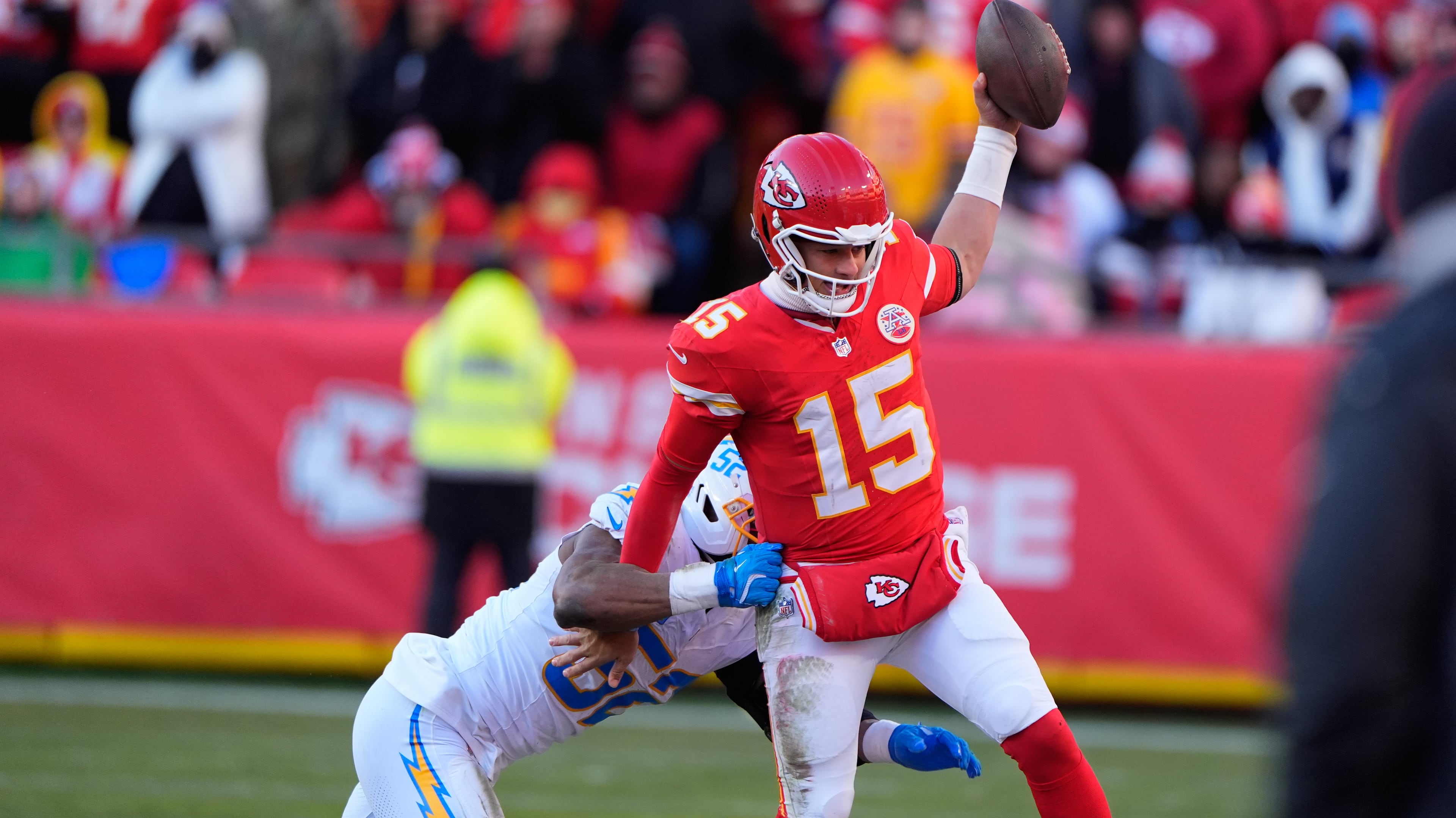 Kansas City Chiefs quarterback Patrick Mahomes (15) is pushed out of bounds by Los Angeles Chargers outside linebacker Khalil Mack, left, during the second half of an NFL football game Sunday, Dec. 14, 2025, in Kansas City, Mo. (AP Photo/Charlie Riedel)