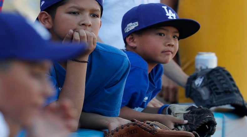 Young fans wait to snag souvenir balls during batting practice before the start of Game 1 of the World Series between the Los Angeles Dodgers and the Houston Astros at Dodger Stadium in Los Angeles on Tuesday, Oct. 24, 2017. (Luis Sinco/Los Angeles Times/TNS)