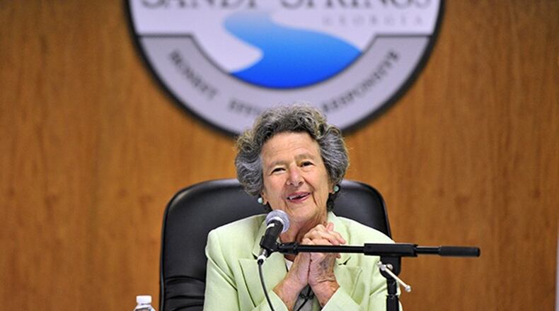 The late Sandy Springs Mayor Eva Galambos led the ceremonial “first bite” with a grapple craw in 2013 to begin the City Springs downtown redevelopment. Soil collected from around the community will be used for landscaping along a City Springs street named in her honor, Galambos Way. AJC FILE