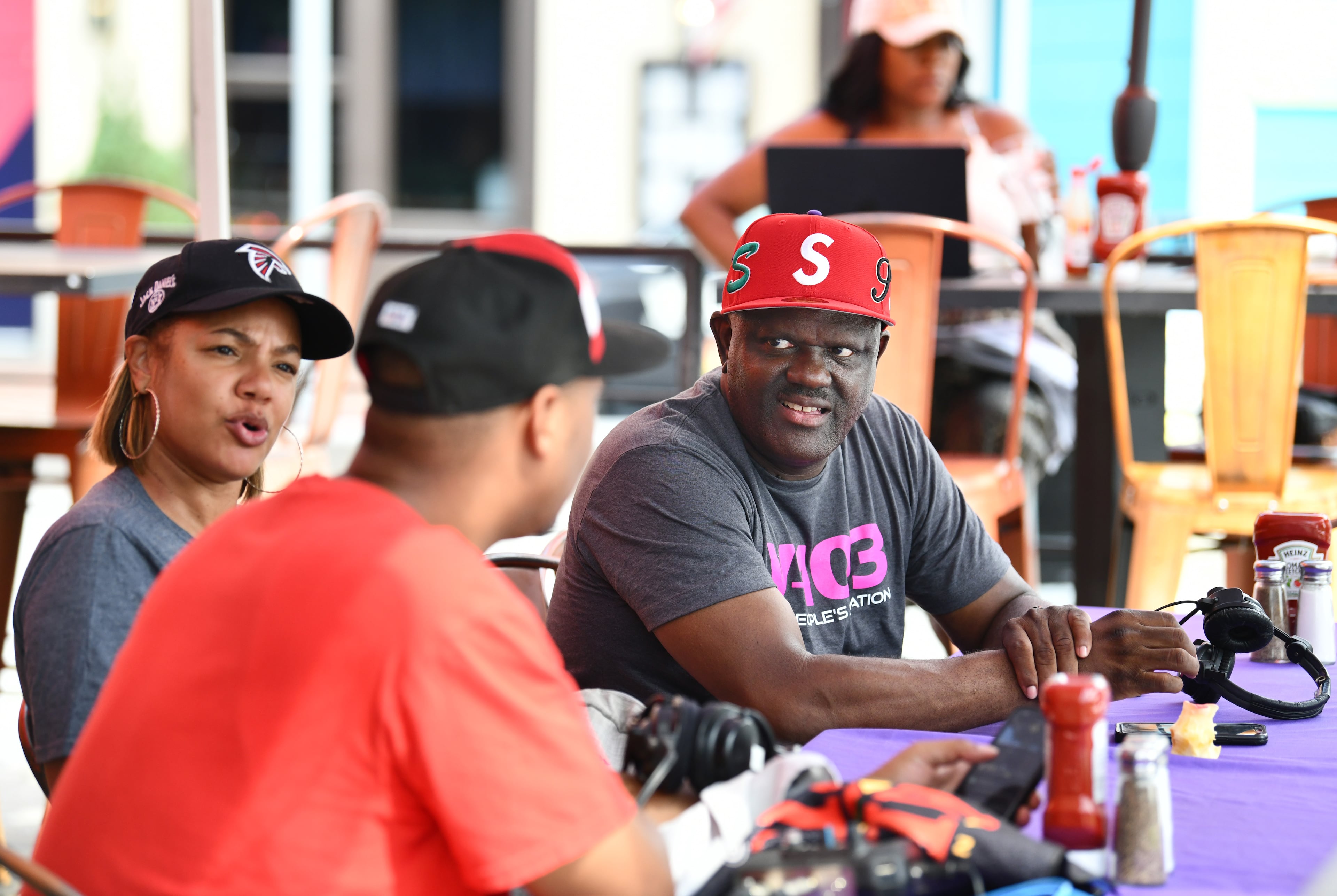 Greg Street (right) talks with Jathiya Majeed (left) and Gordon Robinson (foreground) at a V-103 tent before an Atlanta Falcons pep rally at Atlantic Station, Friday, September 5, 2025 in Atlanta. (Hyosub Shin / AJC)