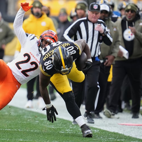Pittsburgh Steelers tight end Darnell Washington (80) avoids a tackle by Cincinnati Bengals safety Geno Stone (22) during the first half of an NFL football game Sunday, Nov. 16, 2025, in Pittsburgh. (AP Photo/Gene J. Puskar)