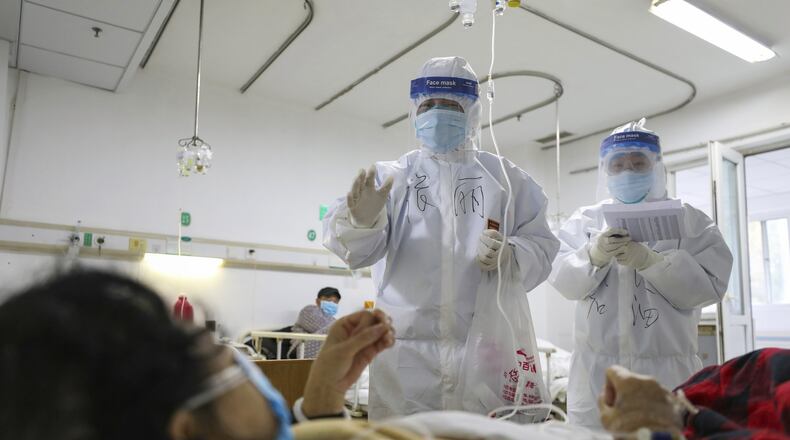The economic impact of the coronavirus is impossible to predict, but the effect is nearly certain to slow growth, said Rajeev Dhawan, director of the Economic Forecasting Center at Georgia State University. Here, medical workers check on patients in Jinyintan Hospital in Wuhan, China, where the virus was first reported. (Chinatopix Via AP)