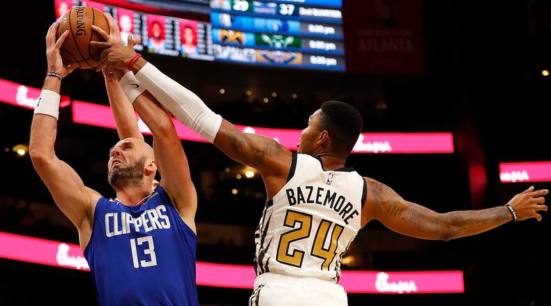 Kent Bazemore of the Atlanta Hawks knocks the ball away from Marcin Gortat of the L.A. Clippers at State Farm Arena on November 19, 2018 in Atlanta, Georgia.